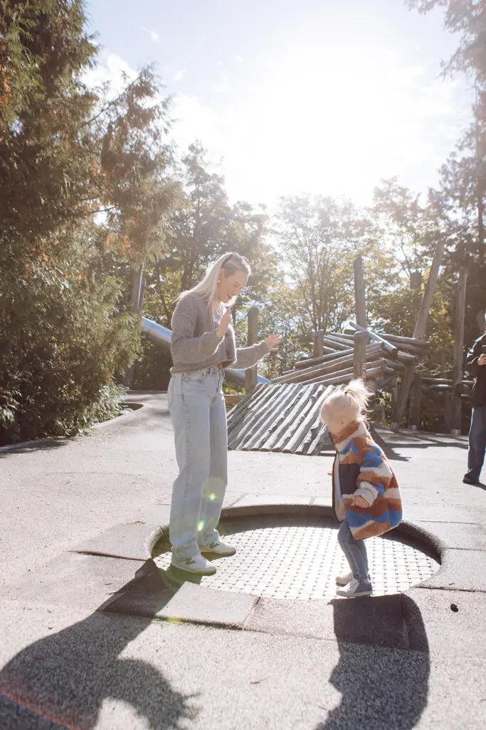A mother and toddler are playing at the local neighbourhood park near Morrison Walk Townhomes