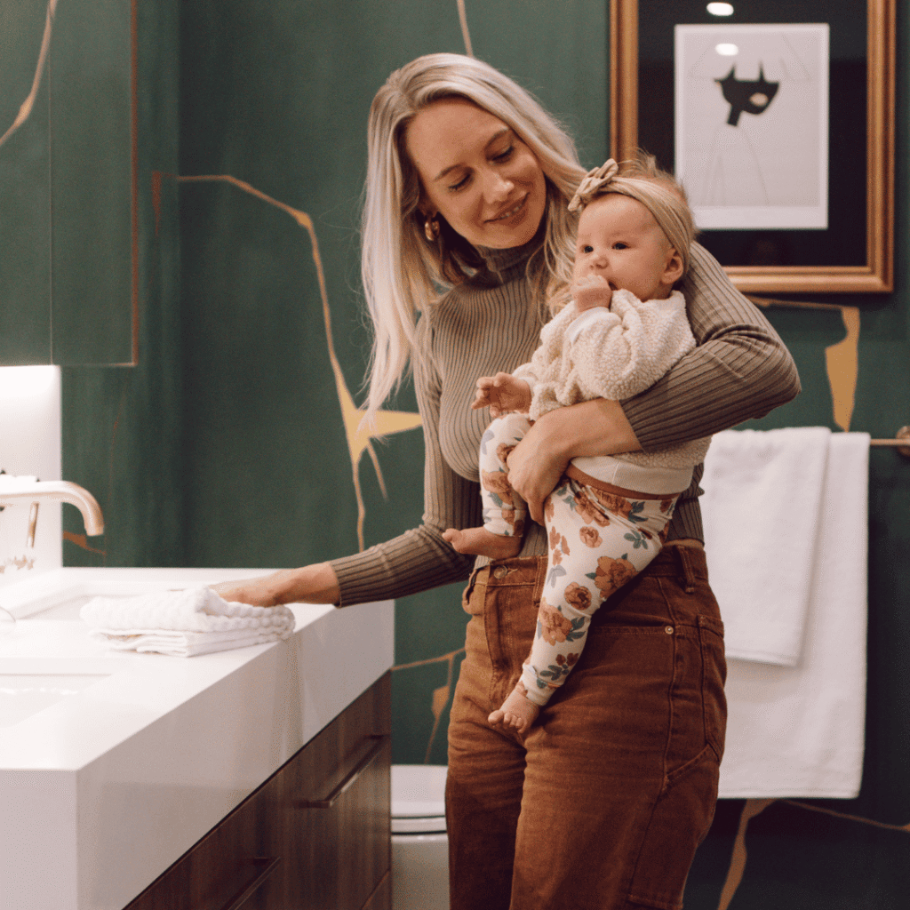 A mother and her baby enjoying the spacious bathroom designed by Karin Bohn of House of Bohn in Morrison Walk Townhomes